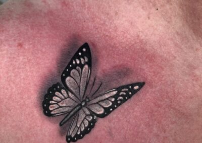 papillon posé sur clavicule d’épaule